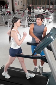 Man assisting a woman on a treadmill