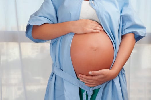Mid section view of a pregnant woman in a hospital