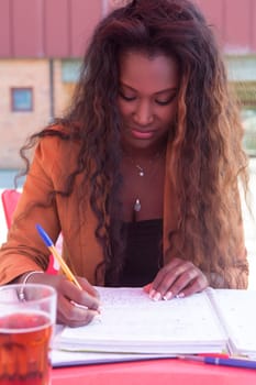 Young african student preparing her exams at a local cafeteria