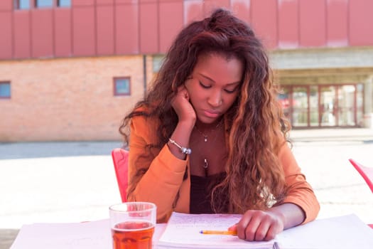 Young african student preparing her exams at a local cafeteria