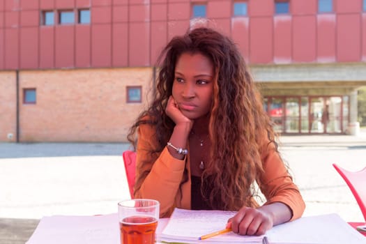 Young african student preparing her exams at a local cafeteria