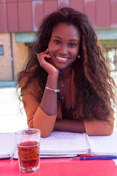 Young african student preparing her exams at a local cafeteria