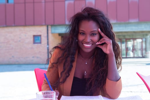 Young african student preparing her exams at a local cafeteria