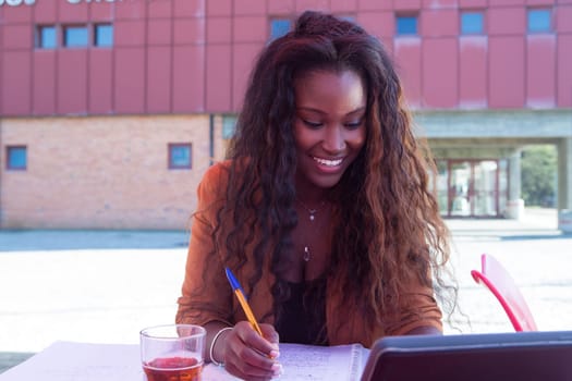Young african student preparing her exams at a local cafeteria