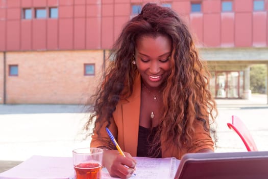 Young african student preparing her exams at a local cafeteria