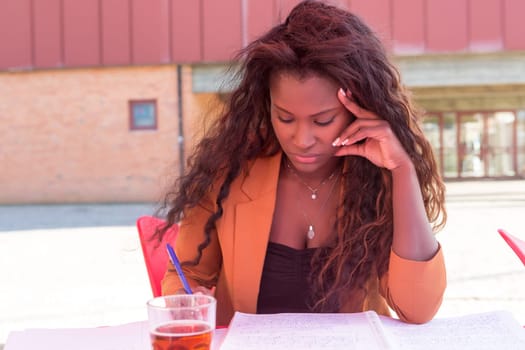 Young african student preparing her exams at a local cafeteria