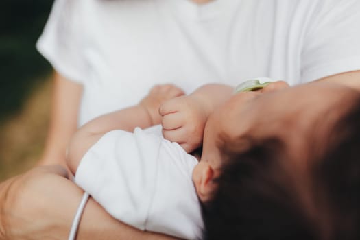 Little baby's hands, mother with baby, care of baby, mother carrying baby. High quality photo