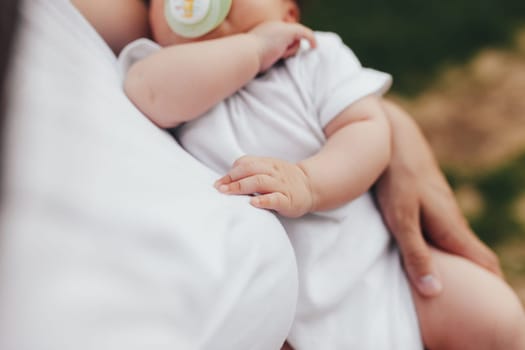 Little baby's hands, mother with baby, care of baby, mother carrying baby. High quality photo