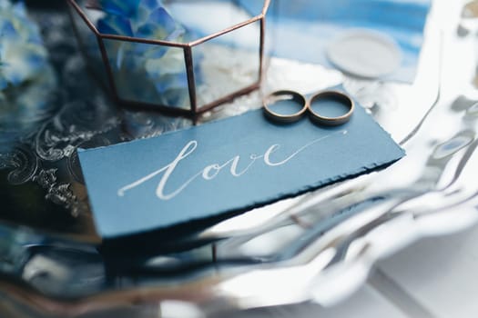 Wedding rings at wedding invitation with decorations. High quality photo