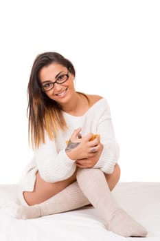 Young beautiful woman having breakfast in bed while working or relaxing with her computer