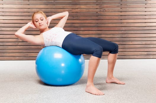 Woman doing sit_ups on a fitness ball