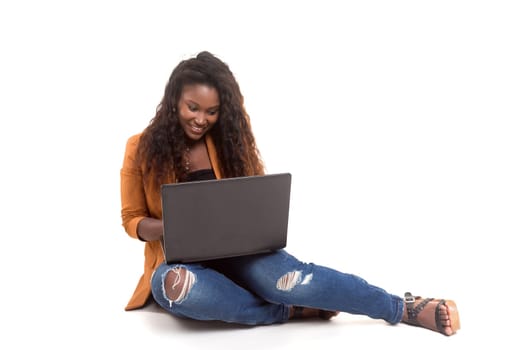 Young african student working with her laptop, isolated over a white background