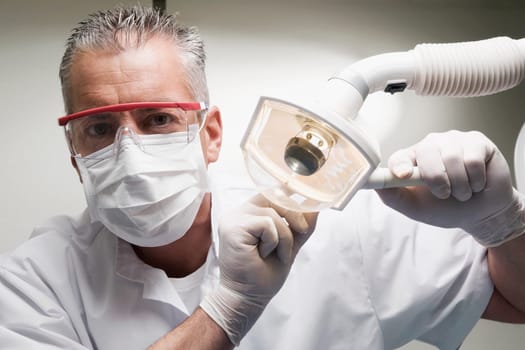 Dentist holding an examination lamp