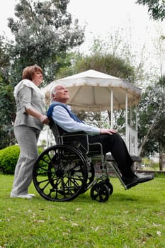 Woman pushing a man sitting in wheelchair