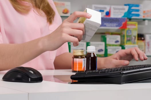 Female pharmacist holding a medicine in a pharmacy