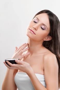 Woman applying moisturizer cream on her neck