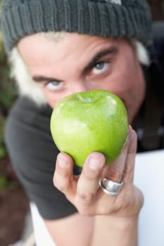 Portrait of a man showing a granny smith apple