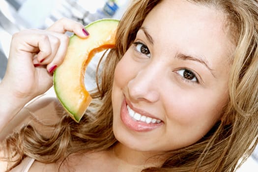 Woman pretending to hold a telephone receiver with a melon slice