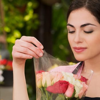 Woman holding a bouquet of flowers in a greenhouse