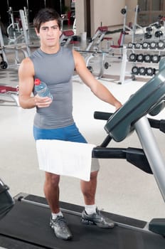 Man holding a water bottle on a treadmill