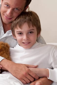 Portrait of a man hugging his son on a hospital bed