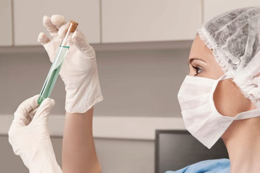 Female lab technician analyzing a sample in a test tube