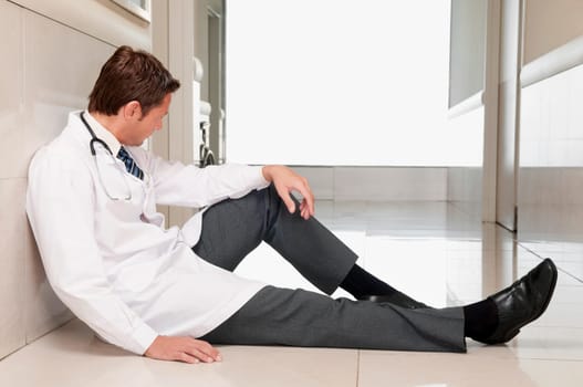 Doctor sitting on the floor looking depressed