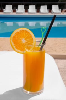 Glass of orange juice at the poolside