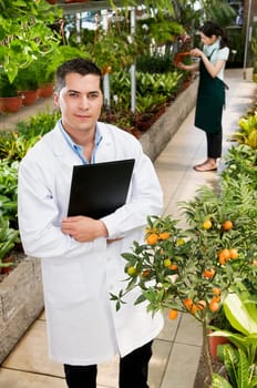 Scientist holding a clipboard in a greenhouse
