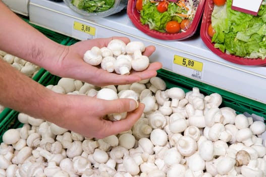 Man buying mushrooms in a supermarket