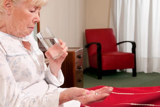 Woman sitting on the bed and taking medicine