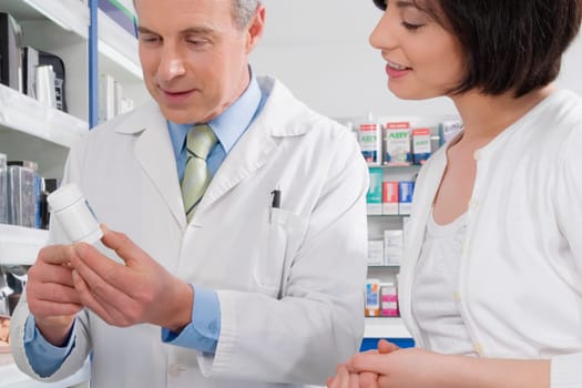 Male pharmacist discussing with a customer