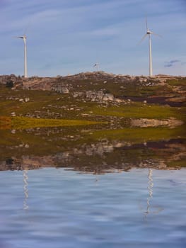 White wind turbines at the top of the mountain
