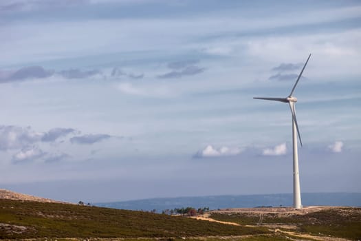 Wind energy turbines, in a landscpae over a beautiful blue sky
