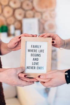 Three lovely family members hold framed picture. High quality photo