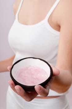 Mid section view of a woman holding a bowl of moisturizer