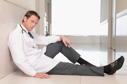 Doctor sitting on the floor looking depressed