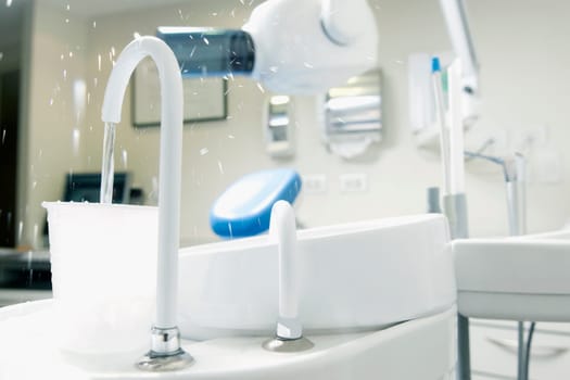 Dental cuspidor with a cup in an examination room