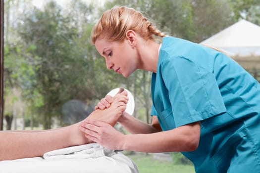 Physiotherapist massaging a personŽs foot