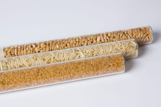 Close_up of brown rice and sugar with wheat in test tubes