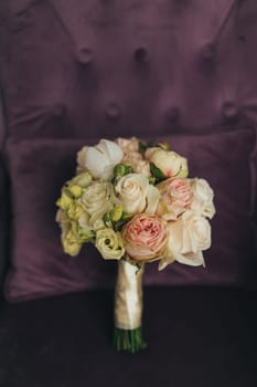 Wedding bouquet on the lilac velvet chair. Blurred background. High quality photo