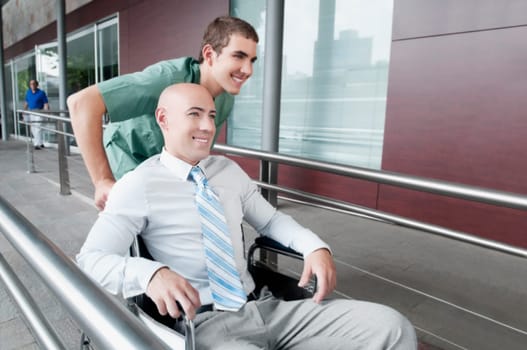 Male nurse pushing a man in wheelchair