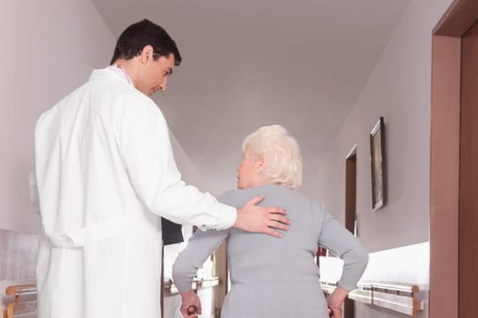 Doctor assisting a woman in walking