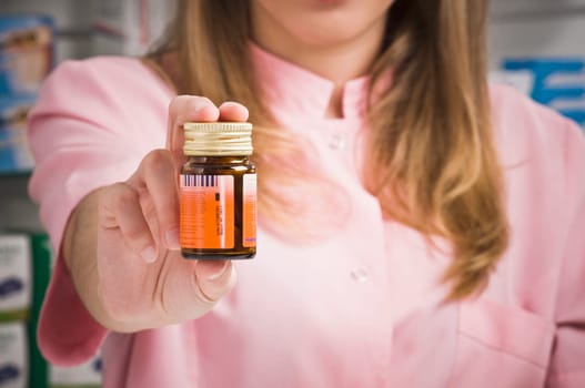 Female pharmacist holding a medicine bottle