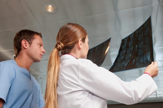 Doctor and a male nurse examining an MRI scan report