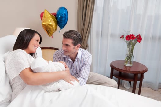 Couple with their newborn baby in a hospital