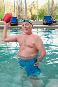 Man playing with a rugby ball in a swimming pool