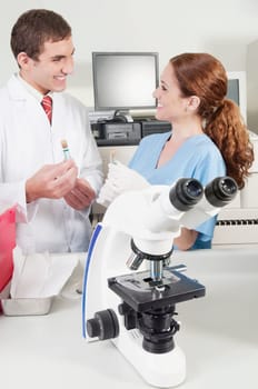 Lab technicians analyzing sample in test tubes