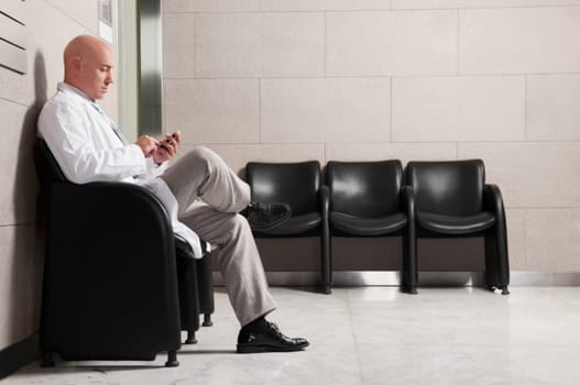 Doctor text messaging on a mobile phone