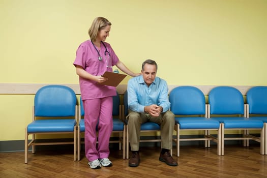 Female nurse consoling a patient in the waiting room